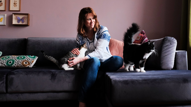 Tanya mit Katze auf Schlafsofa TYME in Samt steingrau