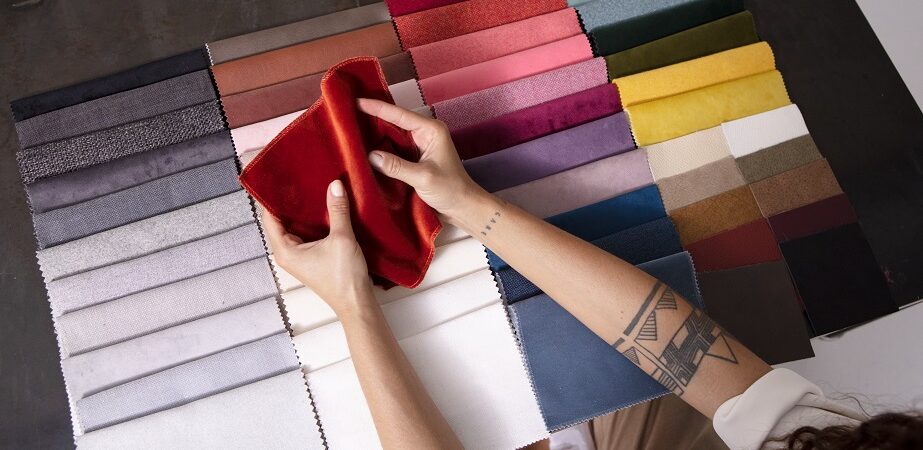 Frau prüft bunte Stoffmuster aus Textil