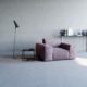 Samtsessel mit Beistelltischen und Lampe in minimalistischem Wohnzimmer