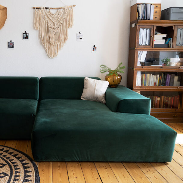 Un canapé en velours vert sapin dans un salon à la décoration d'inspiration vintage.