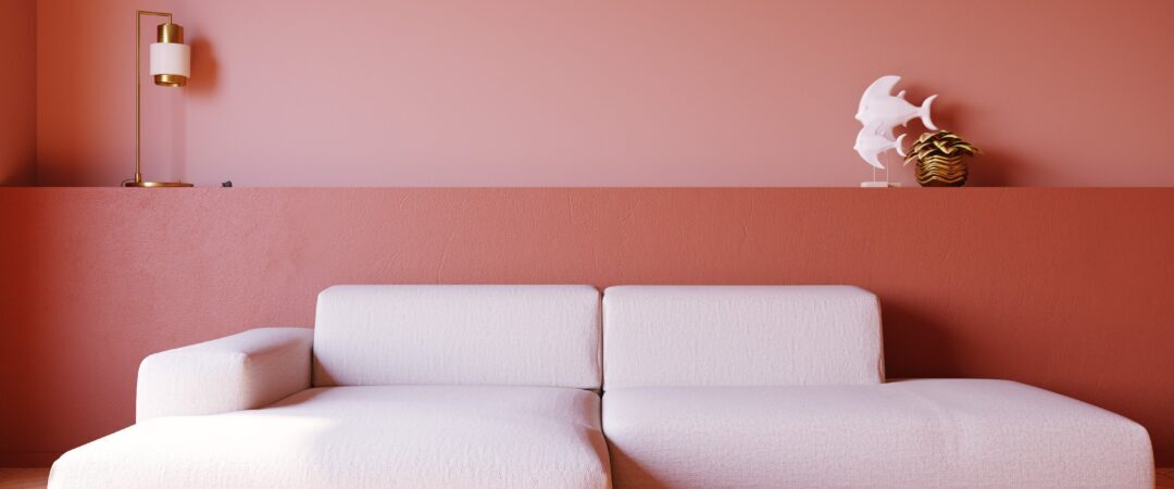 weißes L-Sofa vor roter Wand
