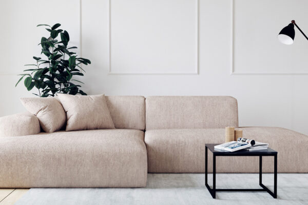 Cordsofa in grau in hellem Wohnzimmer