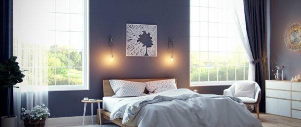 Une chambre cocooning à la déco douce avec un violet pâle sur les murs, du linge de lit gros clair et des tons de bois naturel.