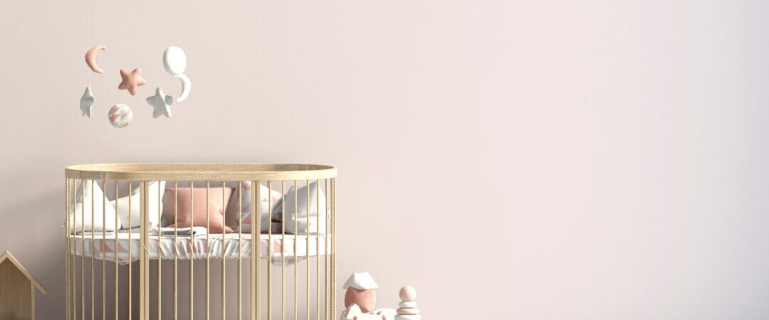 Un lit pour enfant en bois avec un mobile au-dessus.