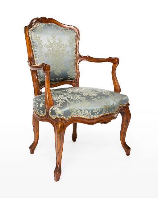 Ein verzierter Sessel mit blassblauer Sitzfläche im Stil des Rokoko.