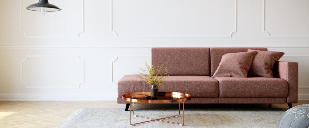 Un canapé de couleur rose foncé avec des coussins assortis.