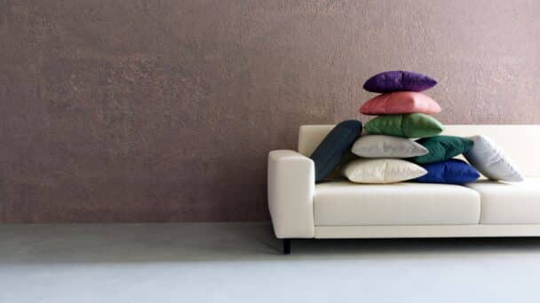 Des coussins de différentes couleurs empilés sur un canapé blanc