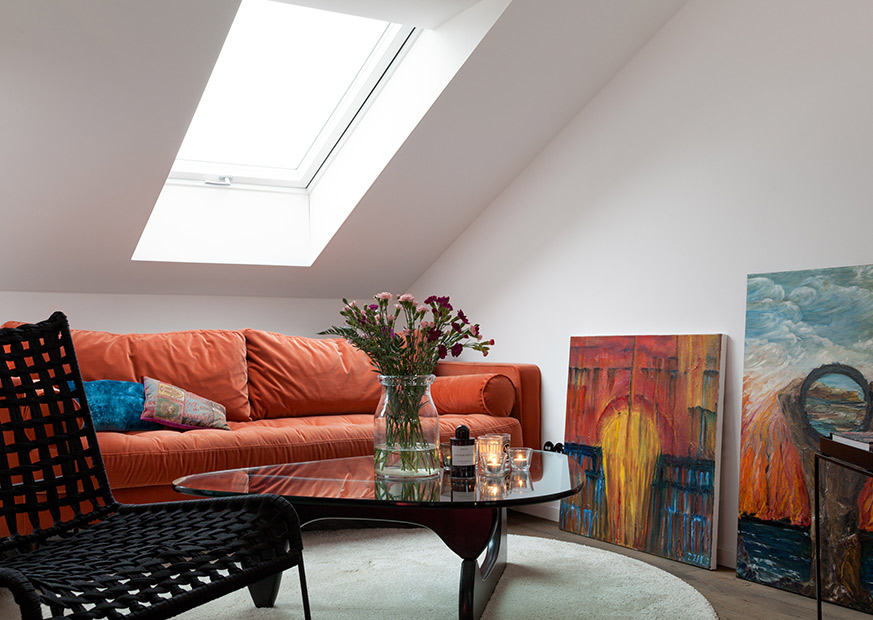 Cloudys Wohnzimmer mit oranger Samtcouch, Couchtisch mit Glasplatte und Ölgemälden